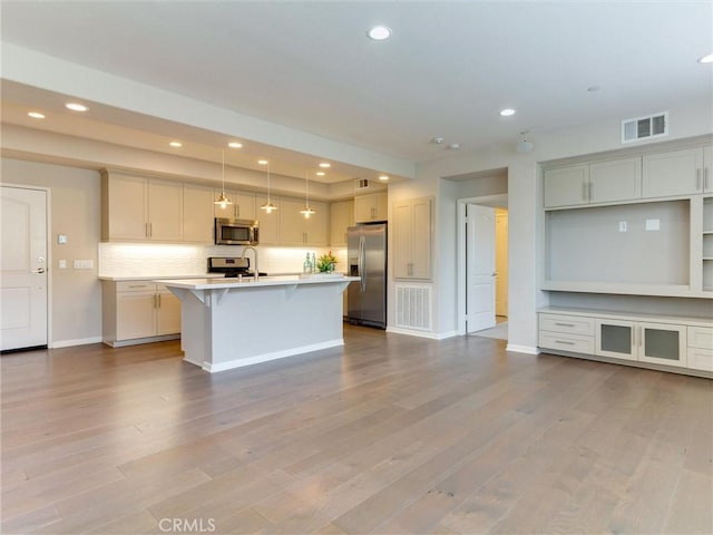 kitchen with a kitchen breakfast bar, stainless steel appliances, baseboards, recessed lighting, and visible vents