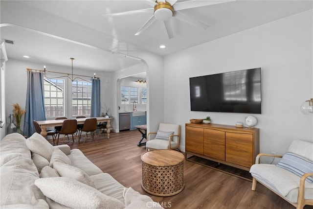 living room featuring arched walkways, a ceiling fan, recessed lighting, wood finished floors, and visible vents