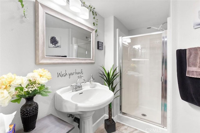 bathroom featuring baseboards and a stall shower