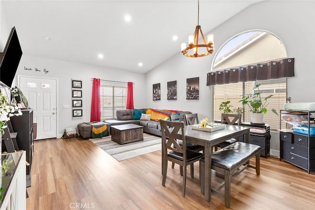 dining room with recessed lighting, high vaulted ceiling, light wood-type flooring, and a chandelier