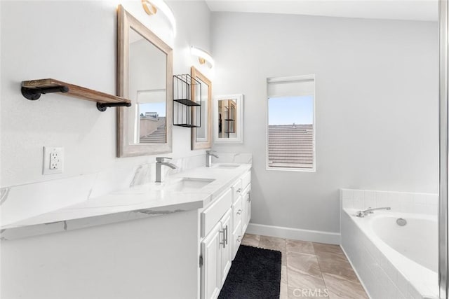 bathroom with a sink, a bath, baseboards, and double vanity