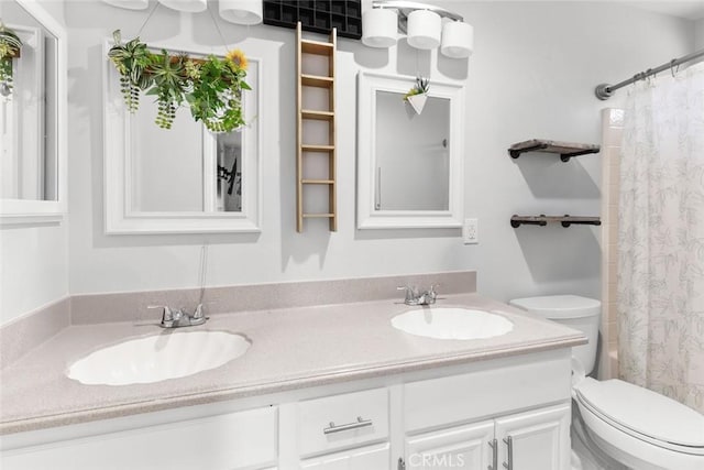 full bathroom with double vanity, a sink, and toilet