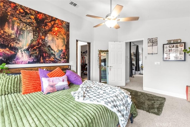 carpeted bedroom featuring ceiling fan, visible vents, vaulted ceiling, baseboards, and a spacious closet