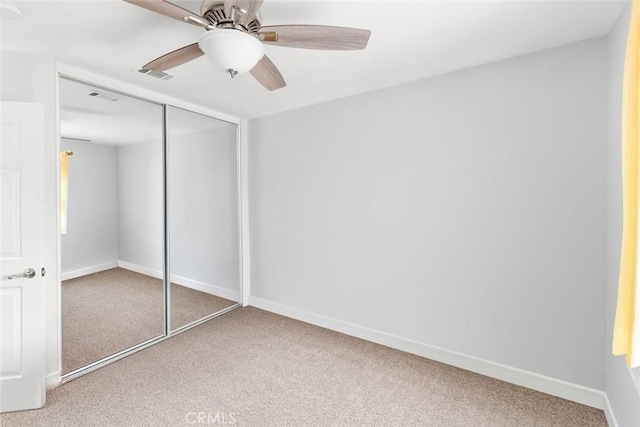 unfurnished bedroom with carpet floors, baseboards, visible vents, and a closet