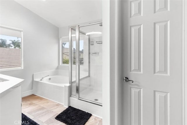 bathroom featuring a shower stall, a bath, and vanity