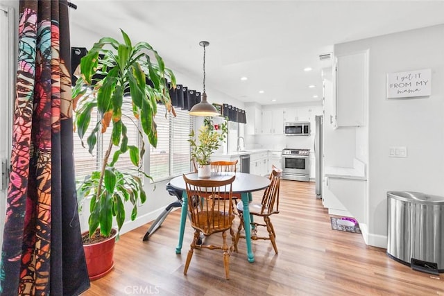 dining area with recessed lighting, baseboards, visible vents, and light wood-style flooring