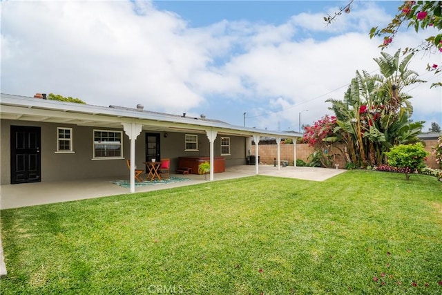 back of property featuring a patio, stucco siding, fence, and a yard