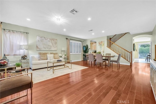 11913 Solitaire Ct, Jurupa Valley, CA 91752 - living room with stairway, arched walkways, wood finished floors, and visible vents