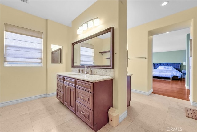 bathroom featuring vanity, baseboards, ensuite bathroom, and tile patterned floors