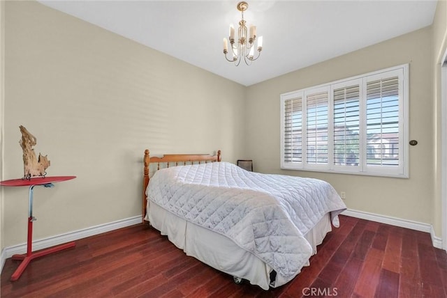 bedroom featuring baseboards, a chandelier, and wood finished floors