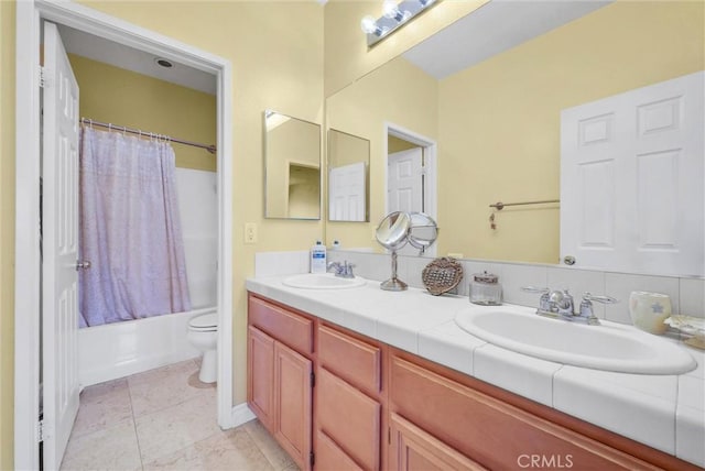 full bath featuring double vanity, a sink, shower / tub combo, and toilet