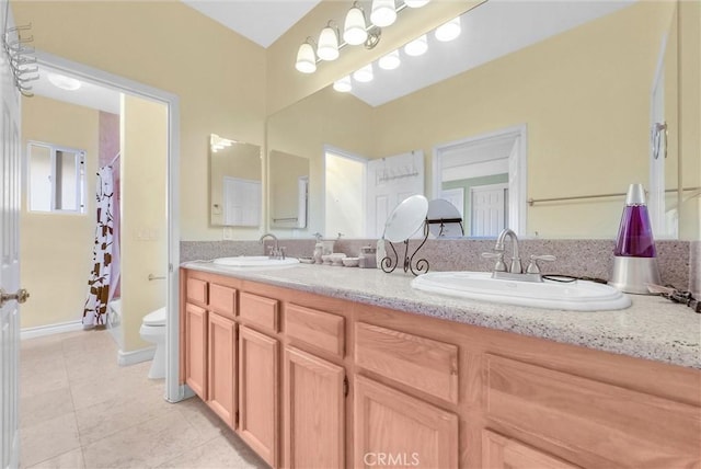 bathroom featuring a sink, a shower with curtain, tile patterned flooring, and toilet