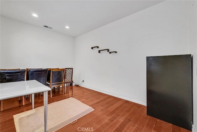 interior space with baseboards, recessed lighting, wood finished floors, and visible vents