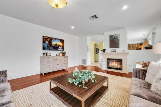 11913 Solitaire Ct, Jurupa Valley, CA 91752 - living area featuring visible vents, a fireplace with flush hearth, wood finished floors, and recessed lighting