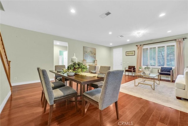 dining area featuring visible vents, wood finished floors, recessed lighting, baseboards, and stairs