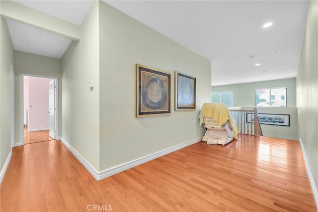 corridor with recessed lighting, baseboards, an upstairs landing, and light wood finished floors