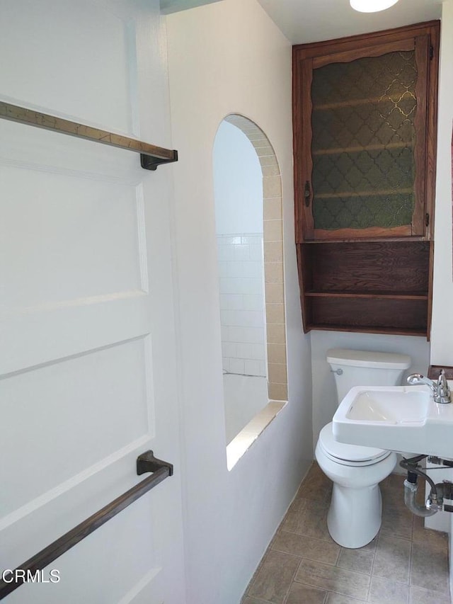 full bathroom with toilet and tile patterned floors