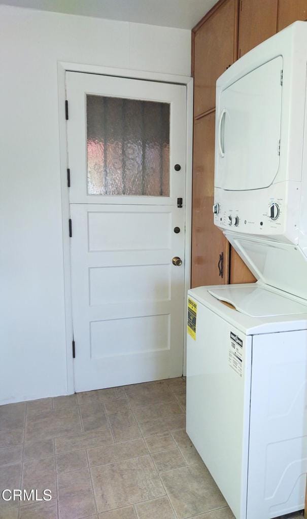 laundry room featuring cabinet space and stacked washing maching and dryer
