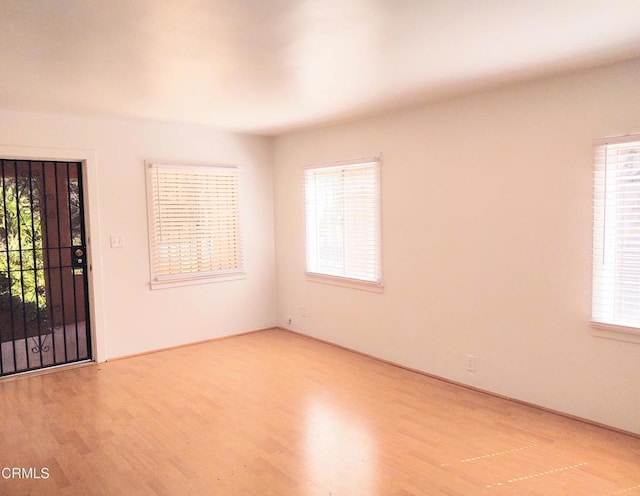 empty room with a wealth of natural light and wood finished floors