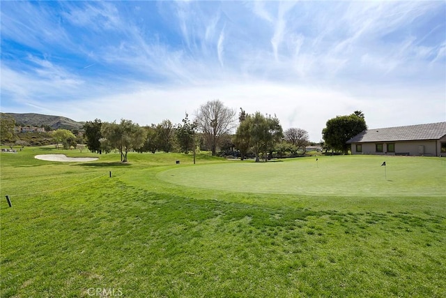 view of home's community featuring a yard and golf course view