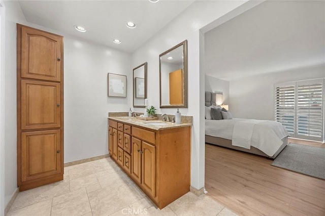 full bathroom with baseboards, a sink, ensuite bathroom, and recessed lighting