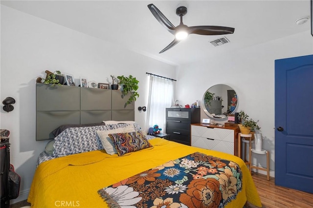 bedroom with visible vents, ceiling fan, and wood finished floors