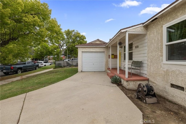 view of home's exterior with stucco siding and concrete driveway