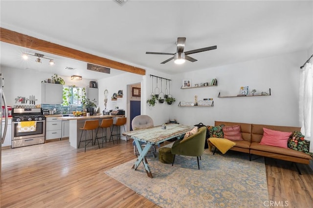 living room featuring a ceiling fan and light wood-style flooring