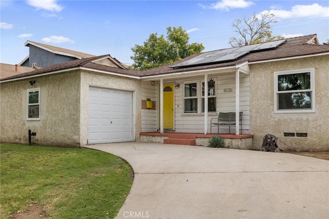 ranch-style house featuring a garage, a front yard, roof mounted solar panels, concrete driveway, and a porch