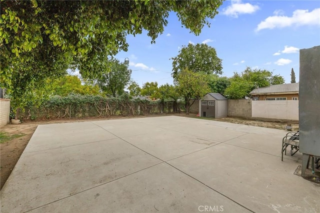view of patio / terrace with a fenced backyard, an outdoor structure, and a shed