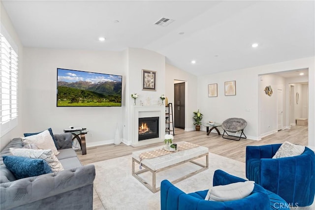 2710 Santa Fiora Dr, Corona, CA 92882 - living room with light wood-style floors, a lit fireplace, baseboards, lofted ceiling, and visible vents