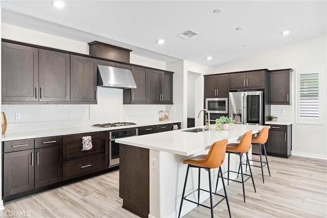 2710 Santa Fiora Dr, Corona, CA 92882 - kitchen with a breakfast bar, a sink, an island with sink, stainless steel appliances, and under cabinet range hood