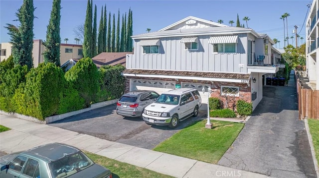 view of property with board and batten siding, an attached garage, and driveway