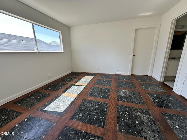 unfurnished room with baseboards