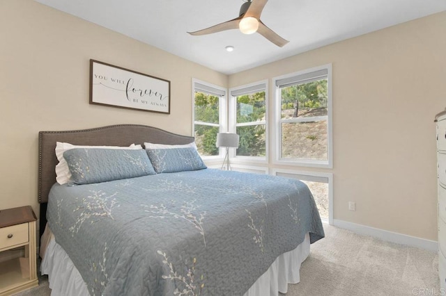 carpeted bedroom with ceiling fan and baseboards