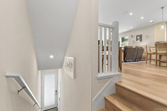 staircase with wood finished floors and recessed lighting