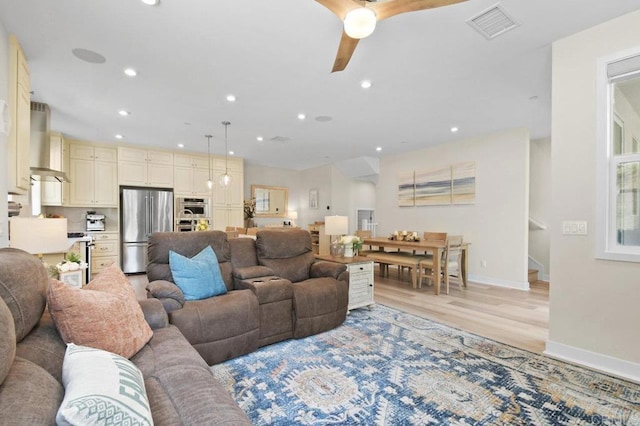 living room with ceiling fan, light wood finished floors, visible vents, and recessed lighting