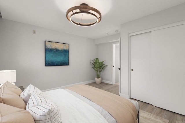 bedroom featuring a closet, baseboards, and light wood-style floors