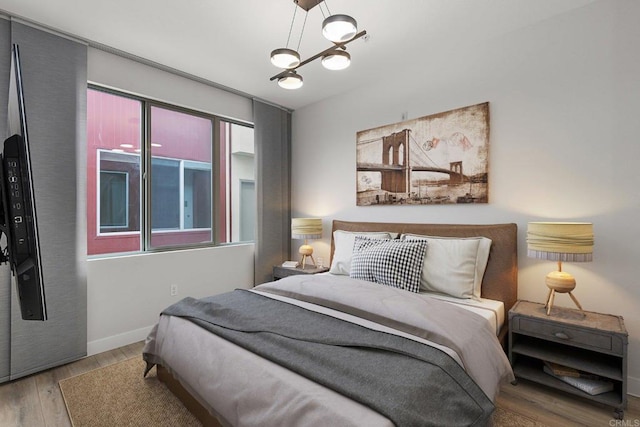 bedroom with baseboards and wood finished floors