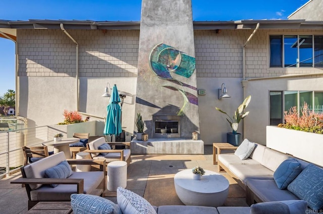 view of patio featuring an outdoor living space with a fireplace