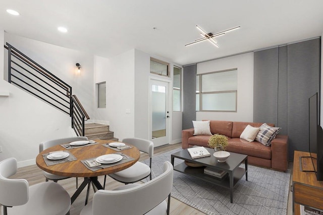 living room featuring stairs, recessed lighting, baseboards, and light wood-style floors