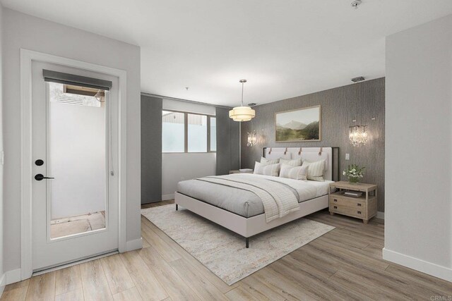 687 S Coast Highway 101 Unit 232, Encinitas, CA 92024 - bedroom featuring an accent wall, light wood-style floors, and wallpapered walls