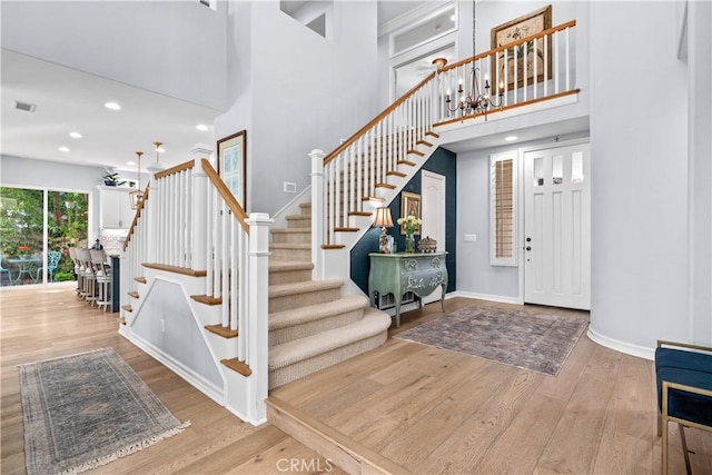 2 Kennedy Ct, Coto De Caza, CA 92679 - stairs featuring recessed lighting, baseboards, wood finished floors, a towering ceiling, and visible vents