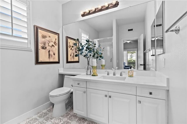 bathroom featuring visible vents, vanity, toilet, baseboards, and a stall shower