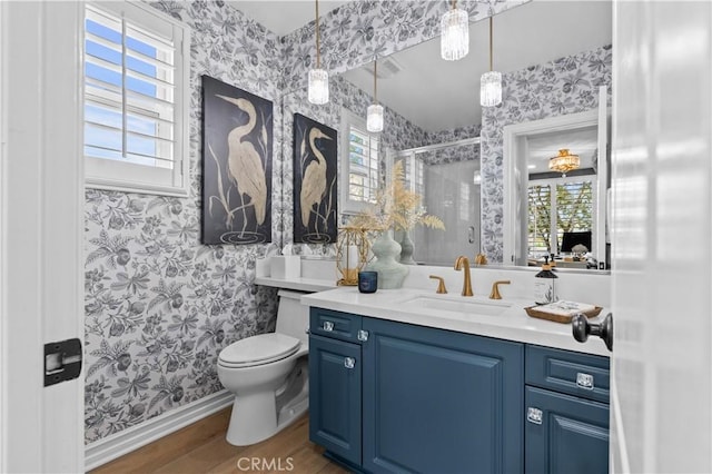 bathroom featuring wallpapered walls, a wealth of natural light, and wood finished floors