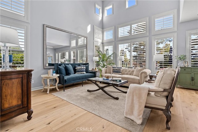 living room with a high ceiling and light wood-style flooring