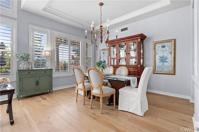 dining room with an inviting chandelier, a healthy amount of sunlight, light wood-type flooring, and visible vents
