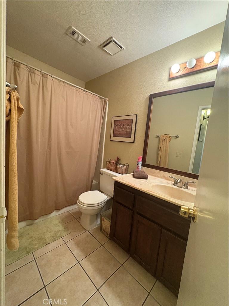 full bath featuring visible vents, tile patterned flooring, toilet, and vanity