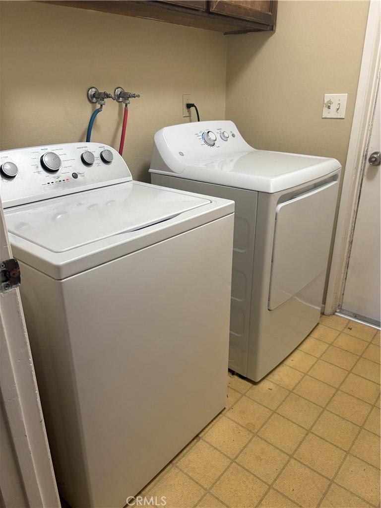 washroom featuring washing machine and clothes dryer and cabinet space