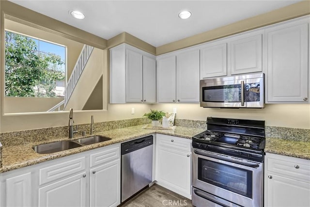 2641 Dunstan Dr, Tustin, CA 92782 - kitchen featuring a sink, white cabinets, stainless steel appliances, and light wood-style flooring